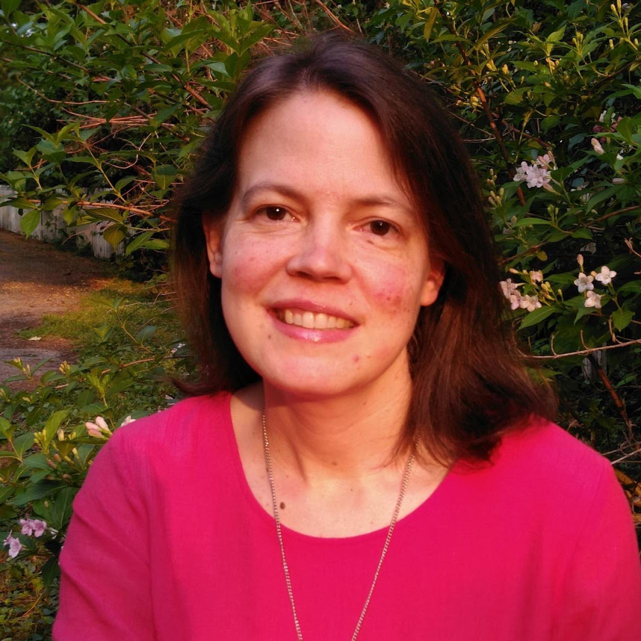 Steph Amici wearing a pink shirt and smiling